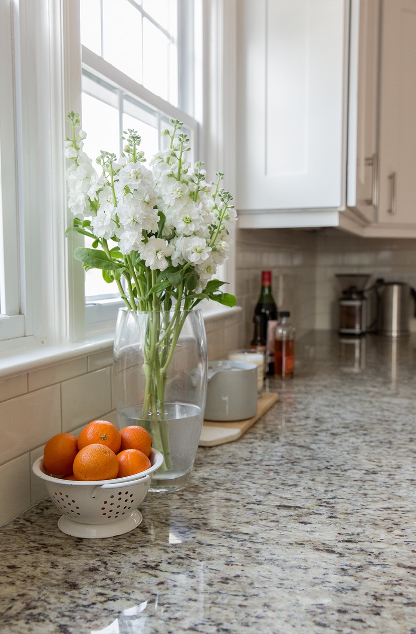 granite counter tops in a kitchen with flowers on the counter