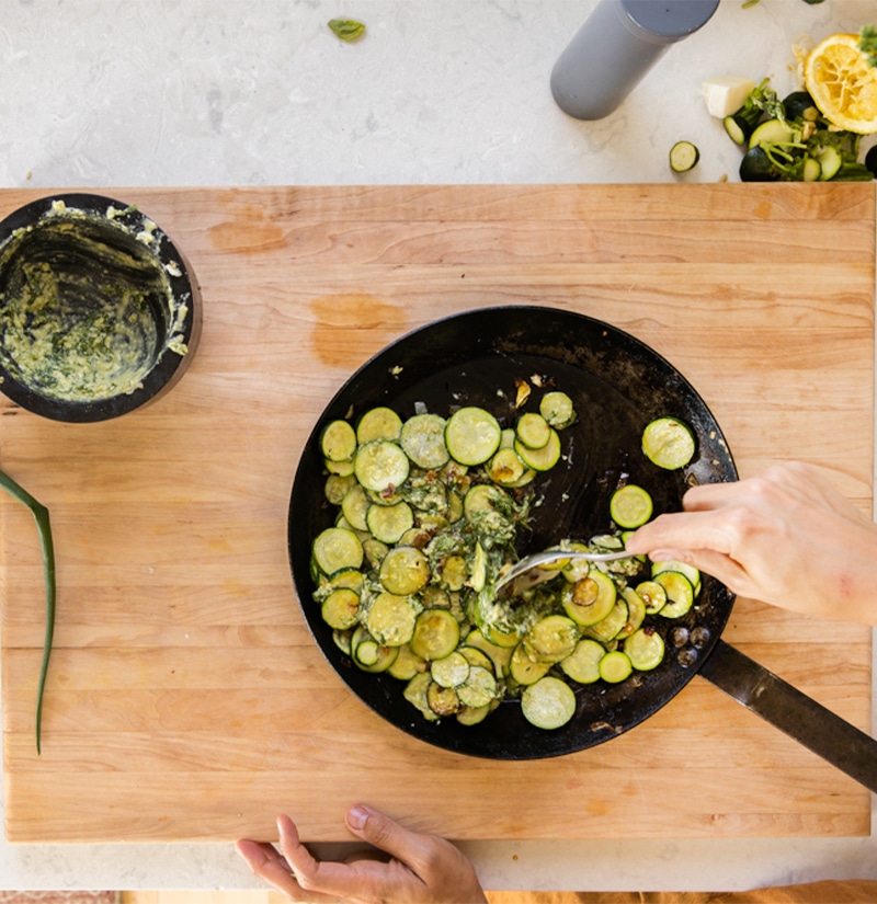 Coating sauteéd zucchini with herb pesto