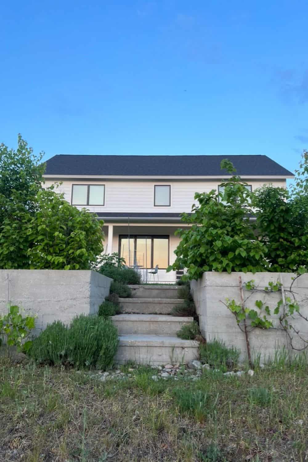 White house with cement walls and garden hedge