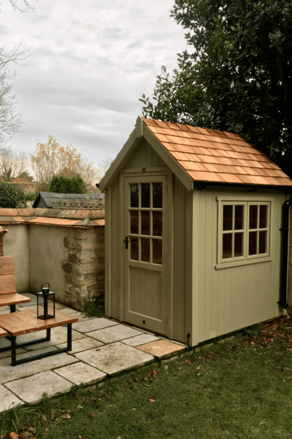 green garden shed with cedar roof