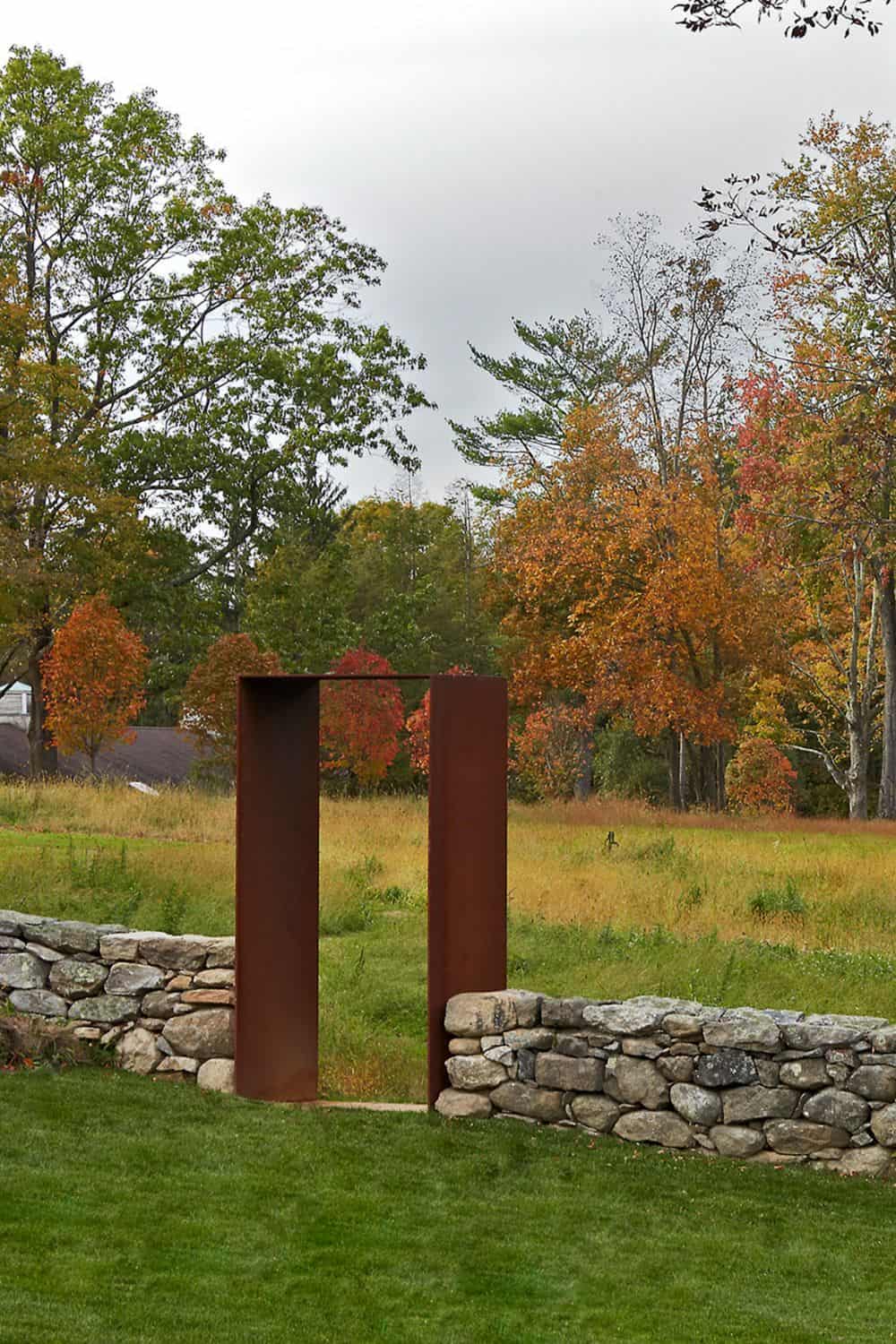 Corten Steel arch with stacked stone wall in fall