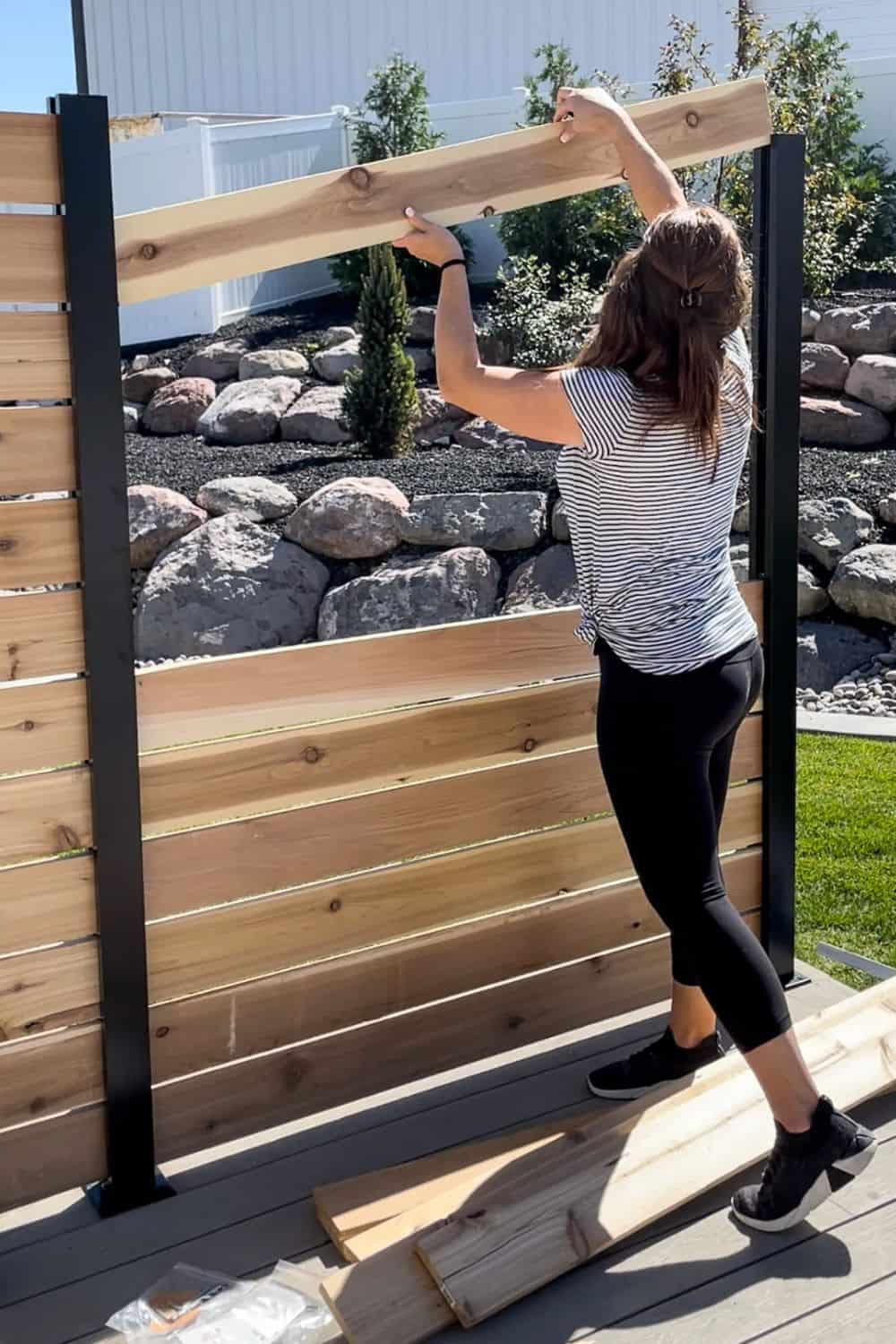 Woman placing boards in a DIY Garden Fence System